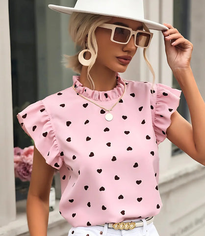 Blusa feminina romântica com estampa de corações, babados nas mangas e tecido leve ideal para ocasiões casuais.