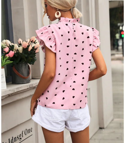 Blusa feminina romântica com estampa de corações, babados nas mangas e tecido leve ideal para ocasiões casuais.