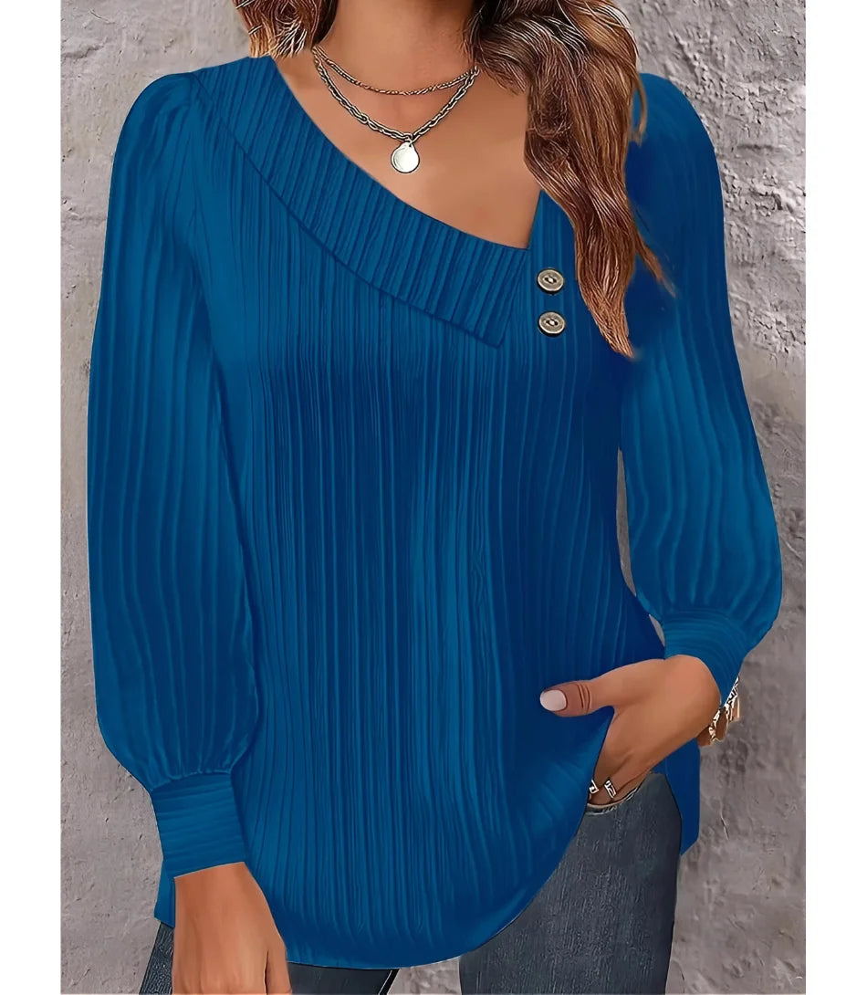Blusa feminina plissada com botões no ombro, design elegante, mangas bufantes e decote assimétrico, ideal para looks sofisticados.