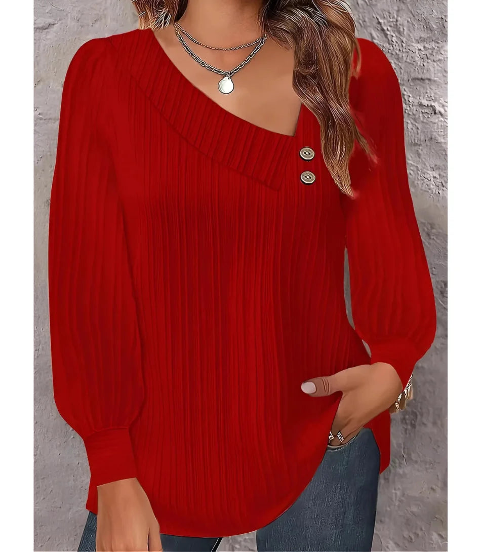 Blusa feminina plissada com botões no ombro, design elegante, mangas bufantes e decote assimétrico, ideal para looks sofisticados.