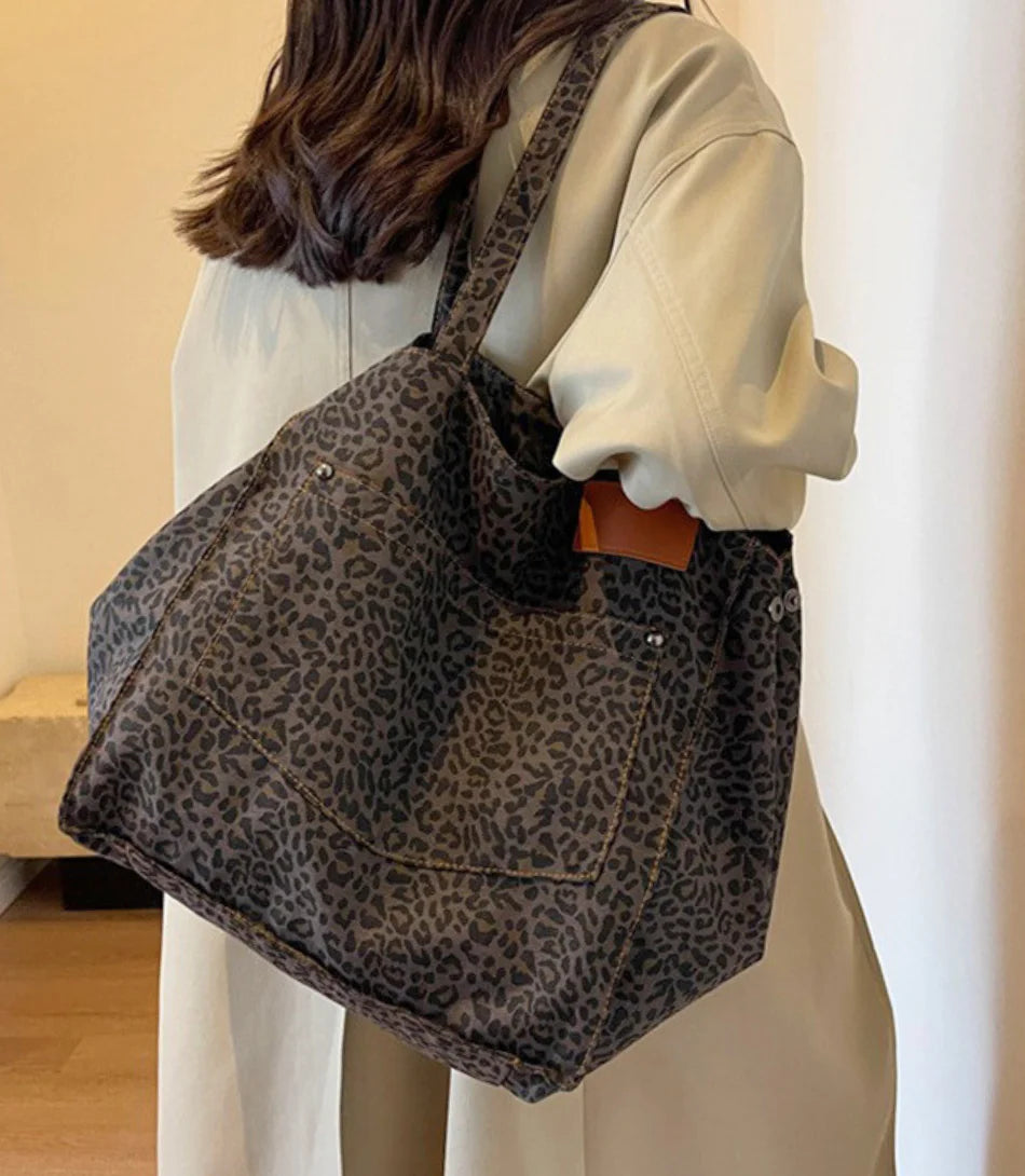 Bolsa Tote Feminina estampada de leopardo em algodão canvas, espaçosa e estilosa, ideal para o dia a dia e looks casuais.