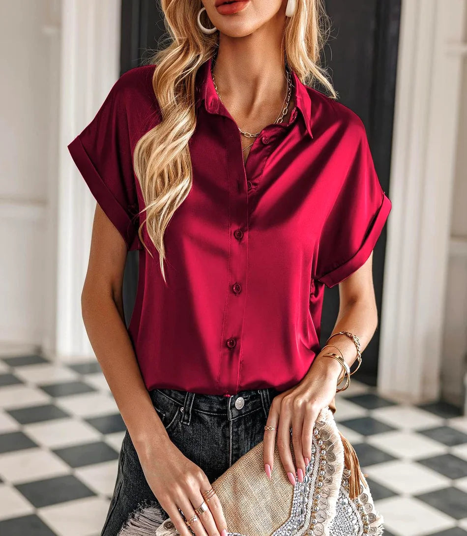 Camisa feminina de cetim manga curta, corte reto, colarinho clássico e mangas dobradas, ideal para looks elegantes e casuais.