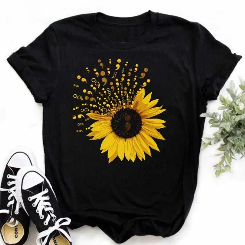 Camiseta feminina estampada com girassol e frases inspiradoras, feita de algodão com corte reto e mangas curtas, ideal para looks casuais.