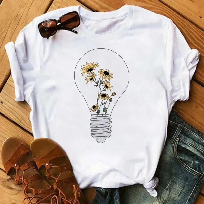 Camiseta feminina estampada com girassol e frases inspiradoras, feita de algodão com corte reto e mangas curtas, ideal para looks casuais.