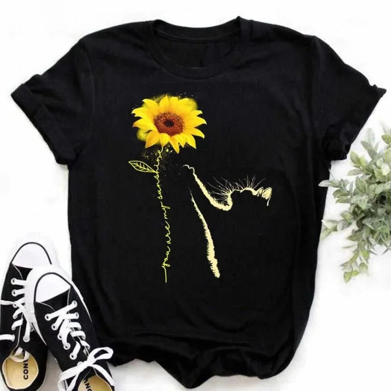 Camiseta feminina estampada com girassol e frases inspiradoras, feita de algodão com corte reto e mangas curtas, ideal para looks casuais.