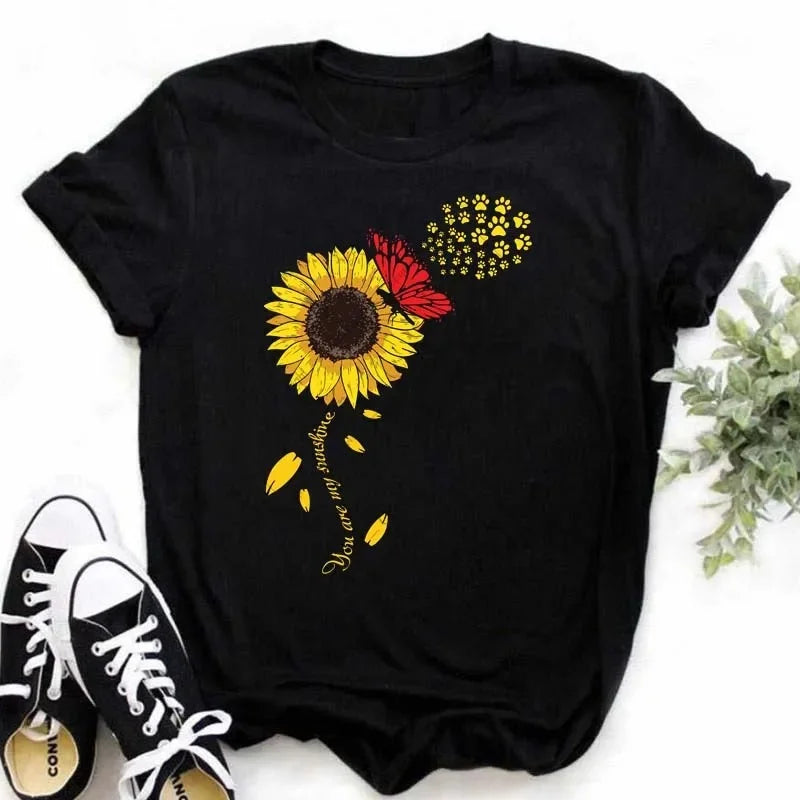 Camiseta feminina estampada com girassol e frases inspiradoras, feita de algodão com corte reto e mangas curtas, ideal para looks casuais.