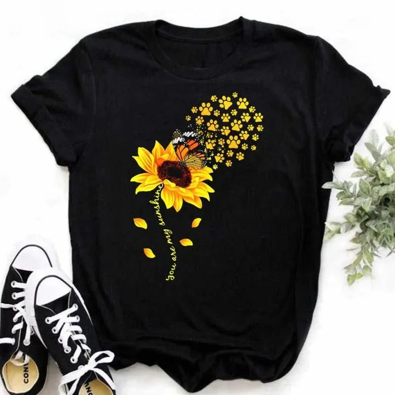 Camiseta feminina estampada com girassol e frases inspiradoras, feita de algodão com corte reto e mangas curtas, ideal para looks casuais.