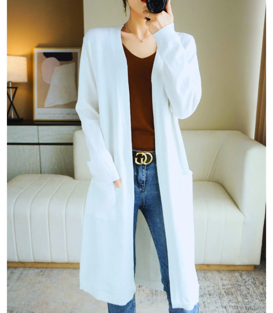 Cardigan feminino longo de malha bege com bolsos e mangas longas, ideal para diversas ocasiões e combinações de looks.