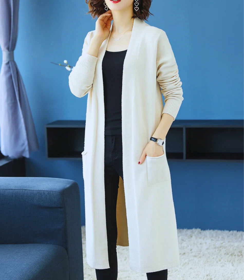 Cardigan feminino longo de malha bege com bolsos e mangas longas, ideal para diversas ocasiões e combinações de looks.