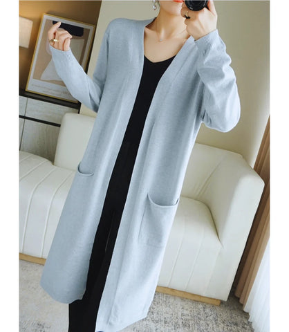 Cardigan feminino longo de malha bege com bolsos e mangas longas, ideal para diversas ocasiões e combinações de looks.