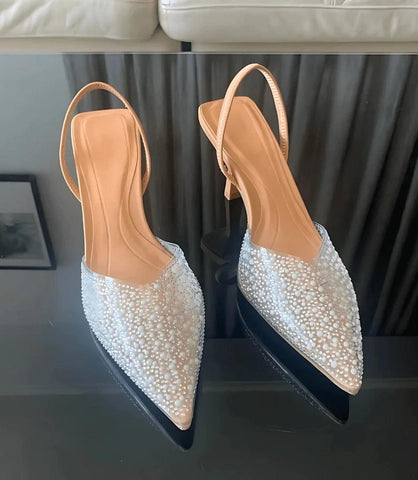 Scarpin slingback transparente com salto médio e pedrarias elegantes, perfeito para eventos formais e festas especiais.
