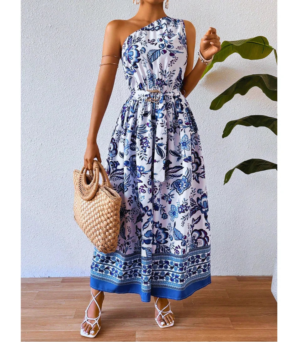 Vestido Midi Boho Floral Um Ombro Feminino com estampa floral, corte midi e ajuste na cintura, perfeito para looks elegantes e versáteis.