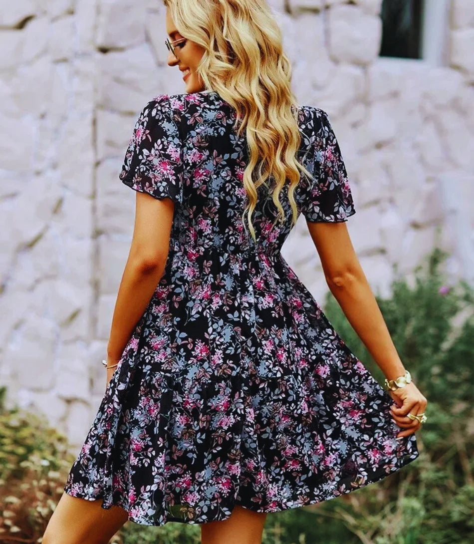 Vestido Boho Estampado Curto com decote em V, mangas curtas e estampa floral, ideal para looks boho chic elegantes e confortáveis.