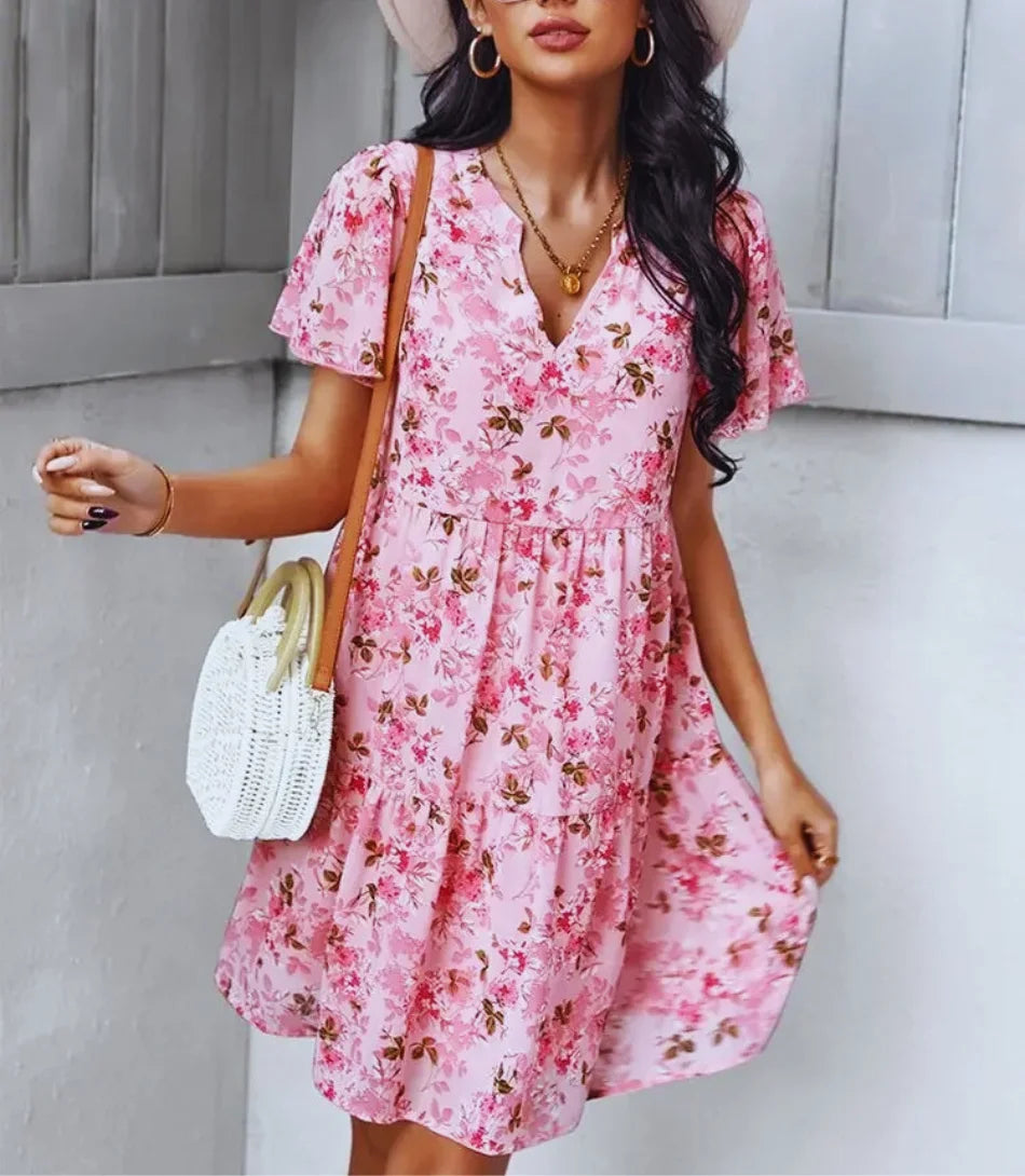 Vestido Boho Estampado Curto com decote em V, mangas curtas e estampa floral, ideal para looks boho chic elegantes e confortáveis.