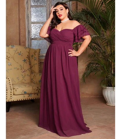 Vestido longo plus size elegante em chiffon, com decote ombro a ombro, babados nas mangas e busto drapeado, perfeito para festas formais. Marsala bordo