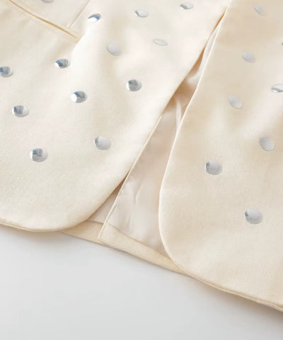 Detalhe das tachas metalizadas na gola do blazer bege feminino