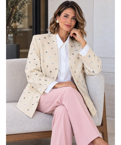 Blazer bege feminino combinado com calça rosa, modelo sentada