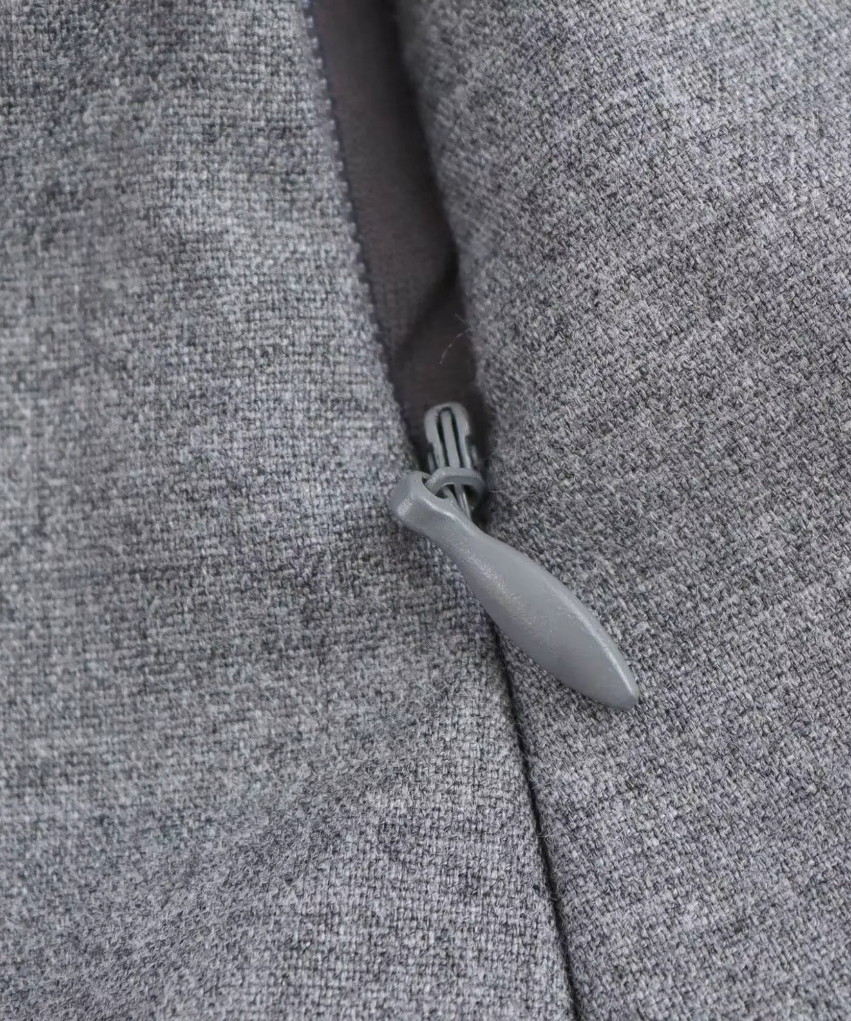 Detalhe do zíper invisível lateral da blusa peplum cinza