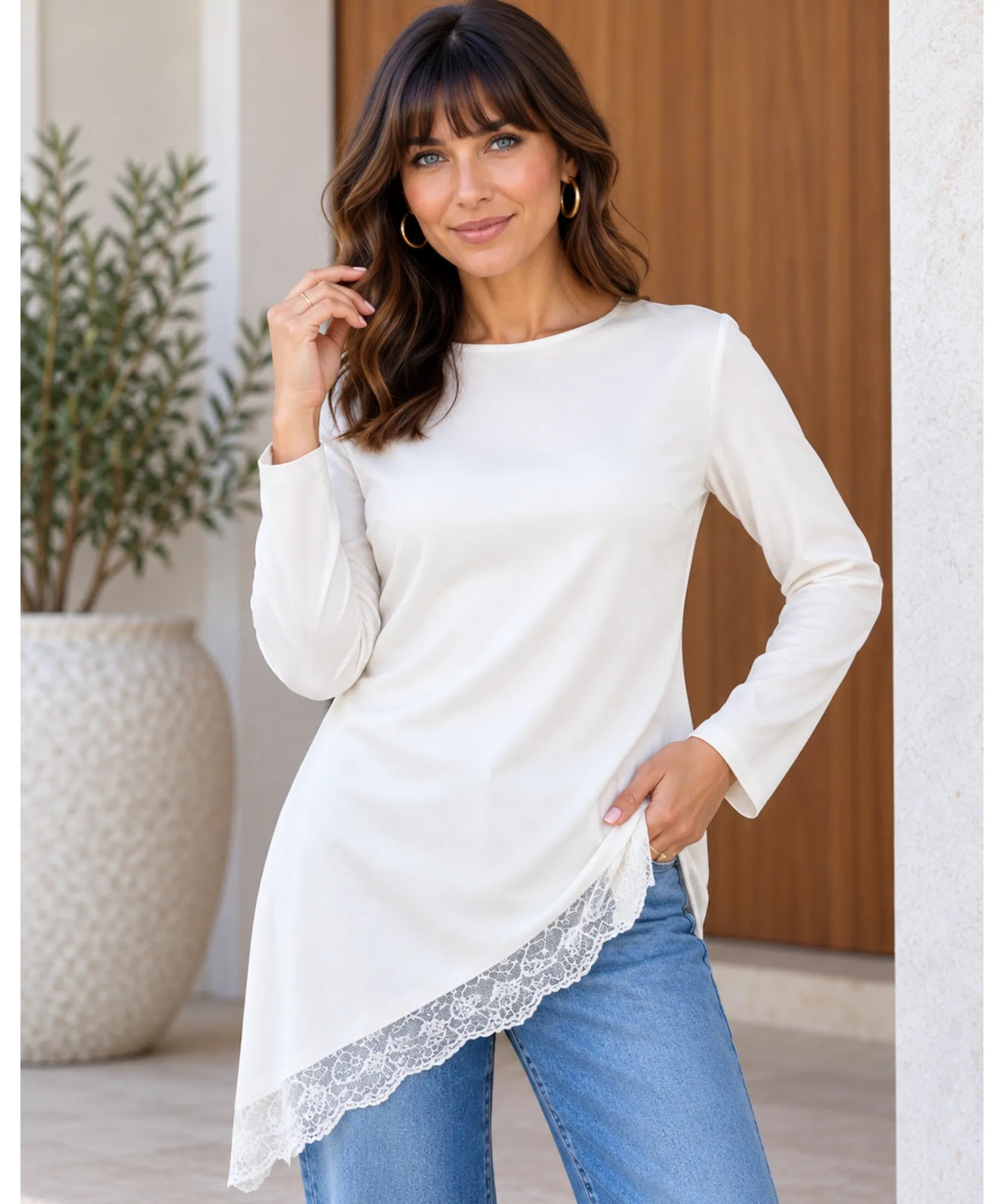 Blusa assimétrica com renda branca vestida com calça jeans