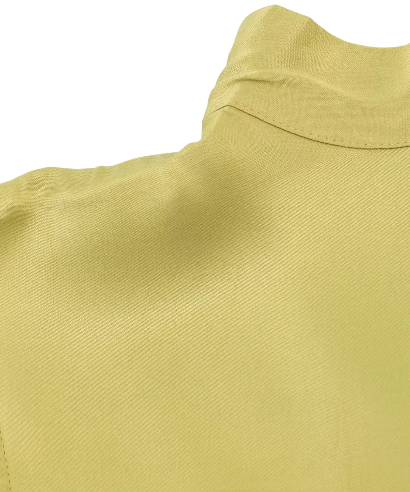 Detalhe da gola alta e do brilho da blusa de cetim verde limão