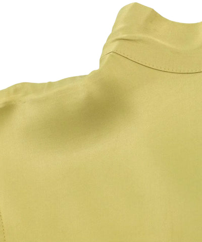 Detalhe da gola alta e do brilho da blusa de cetim verde limão