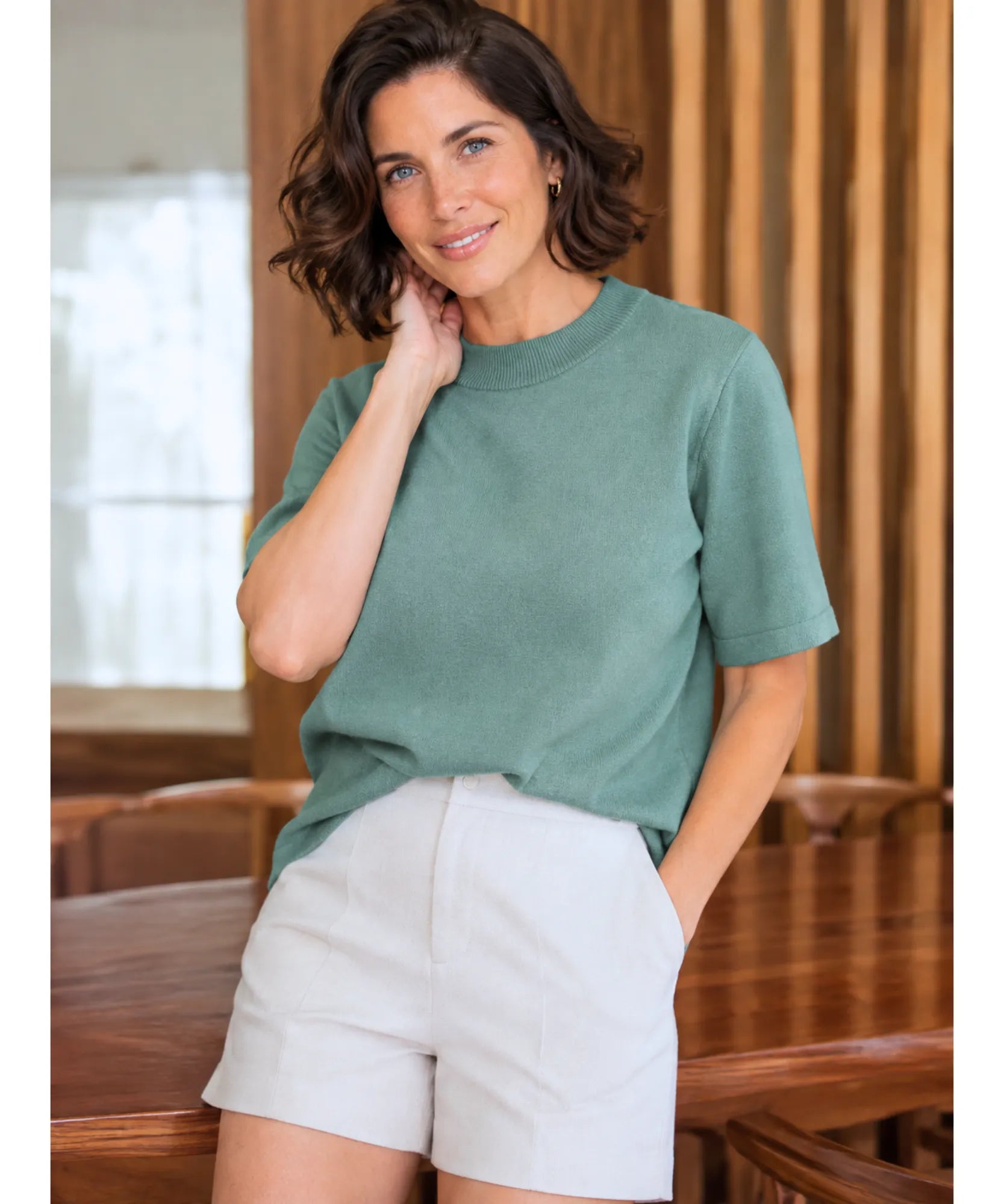 Blusa de malha feminina verde claro combinada com shorts branco