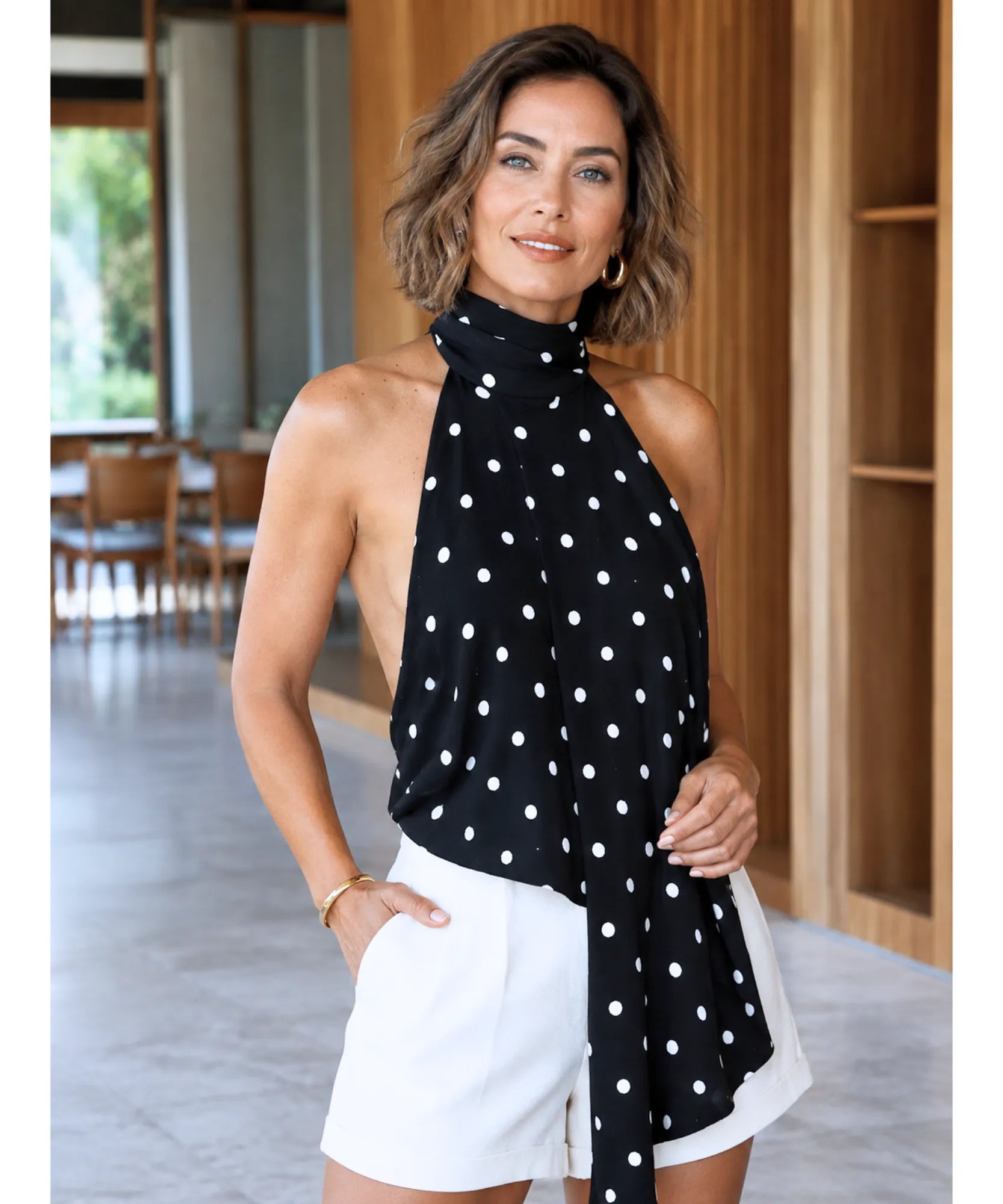 Blusa feminina preta poá frente única Nise - modelo caminhando em ambiente interno