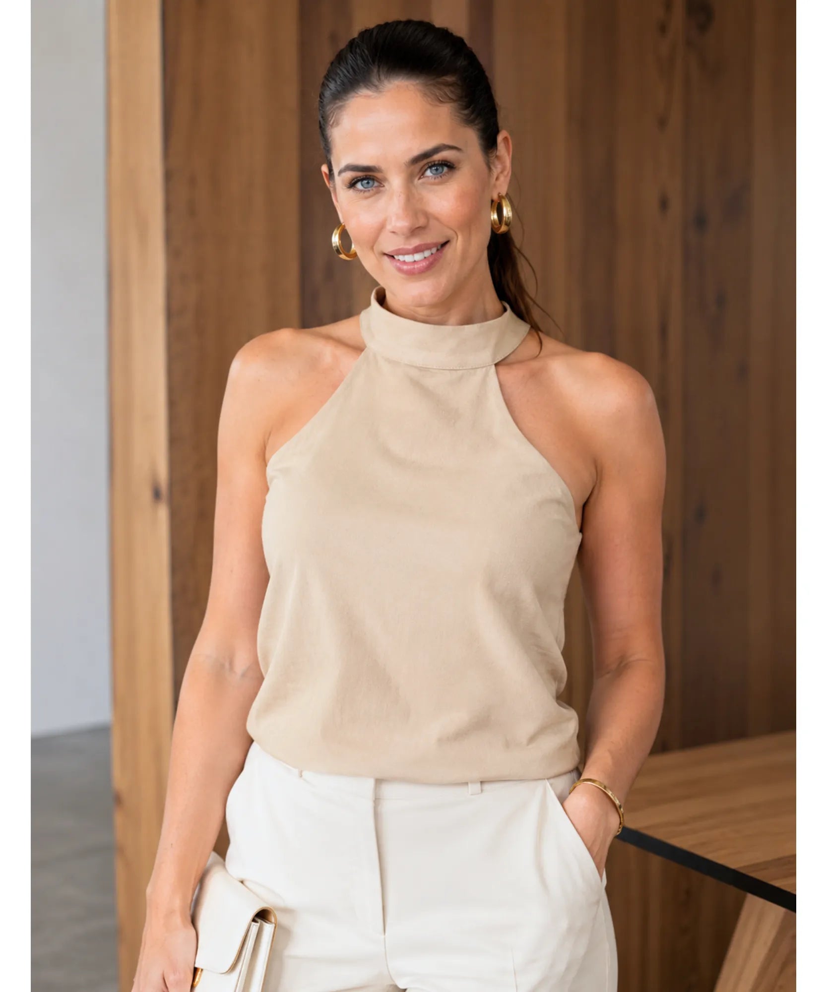 Modelo usando blusa frente única feminina em linho bege com brincos e bolsa de mão