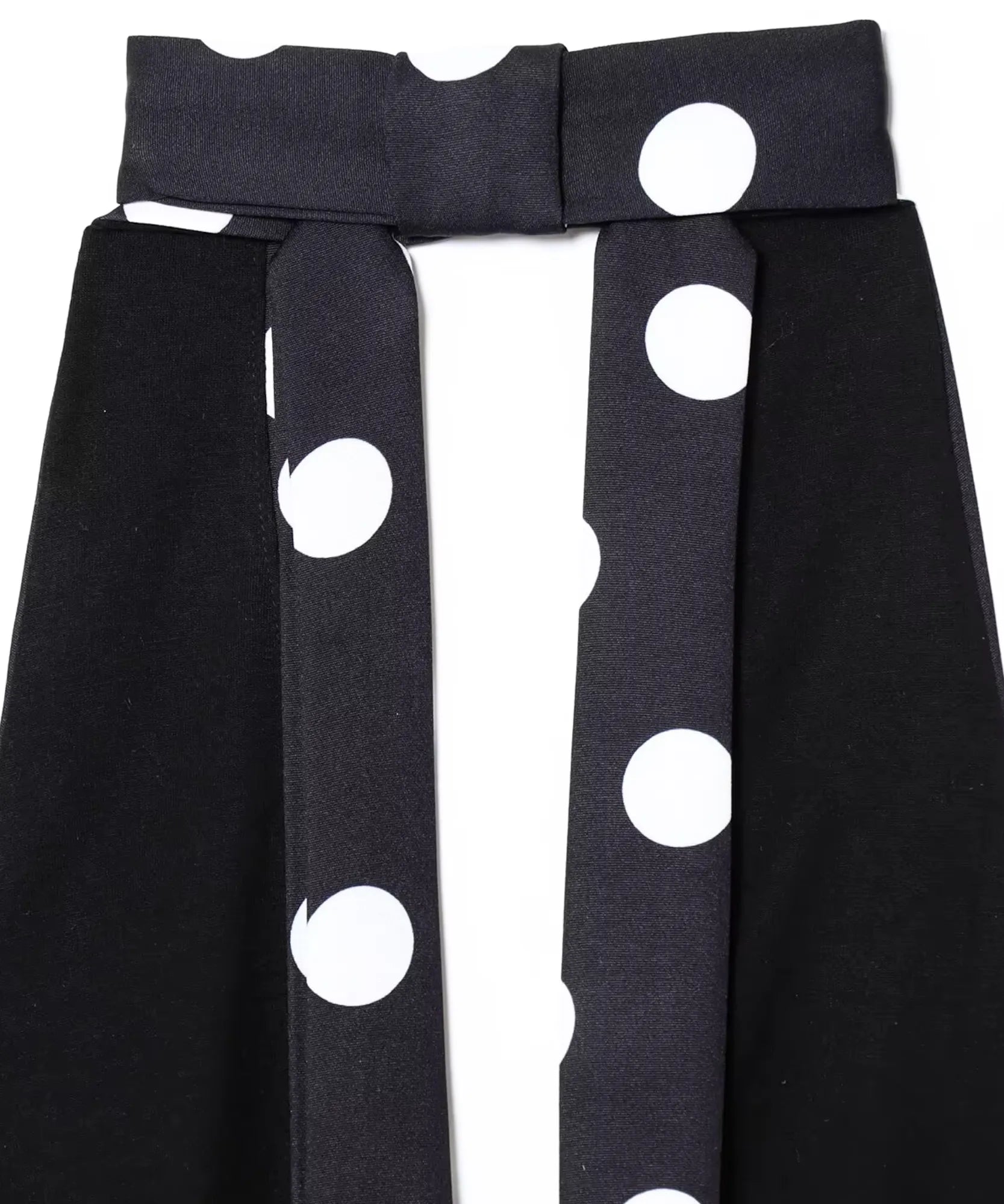 Detalhe das tiras e do recorte do busto da blusa frente única preta estampada em poá branco