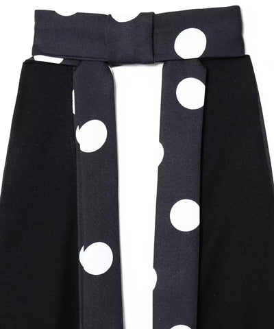 Detalhe das tiras e do recorte do busto da blusa frente única preta estampada em poá branco