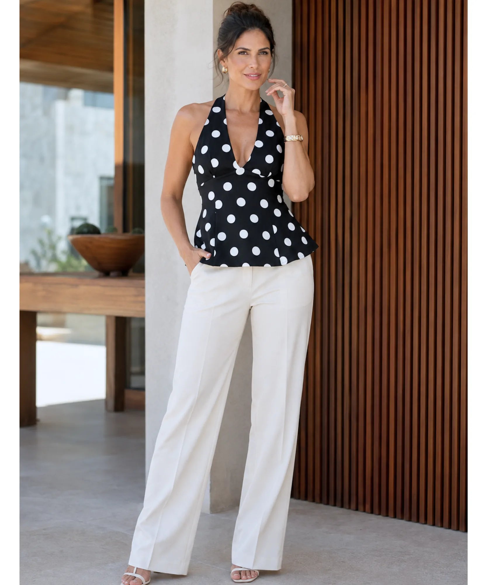 Blusa frente única preta poá branco em look completo dos pés à cabeça, com calça branca e sandália