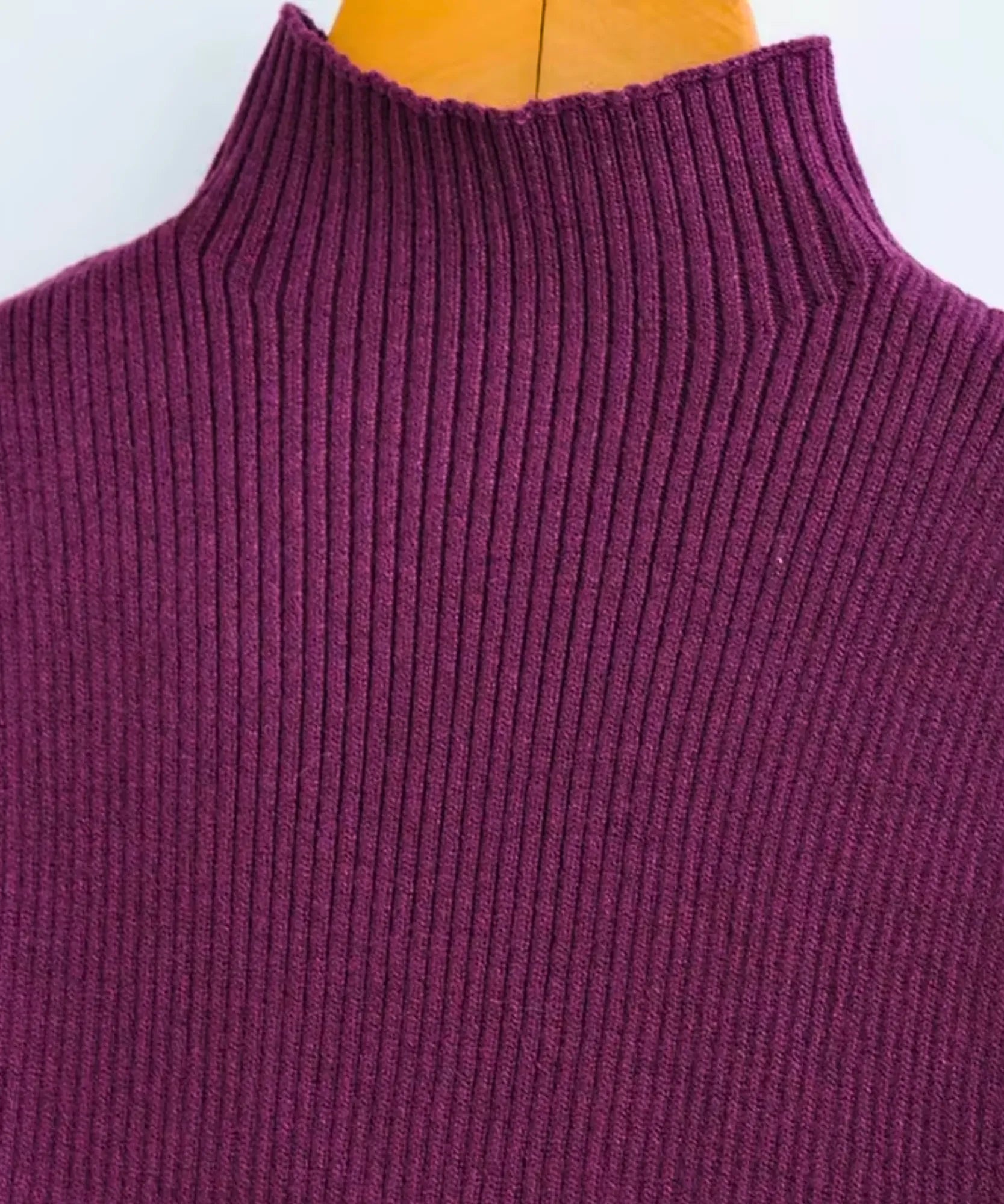 Detalhe da gola alta canelada da blusa sem manga feminina na cor roxa