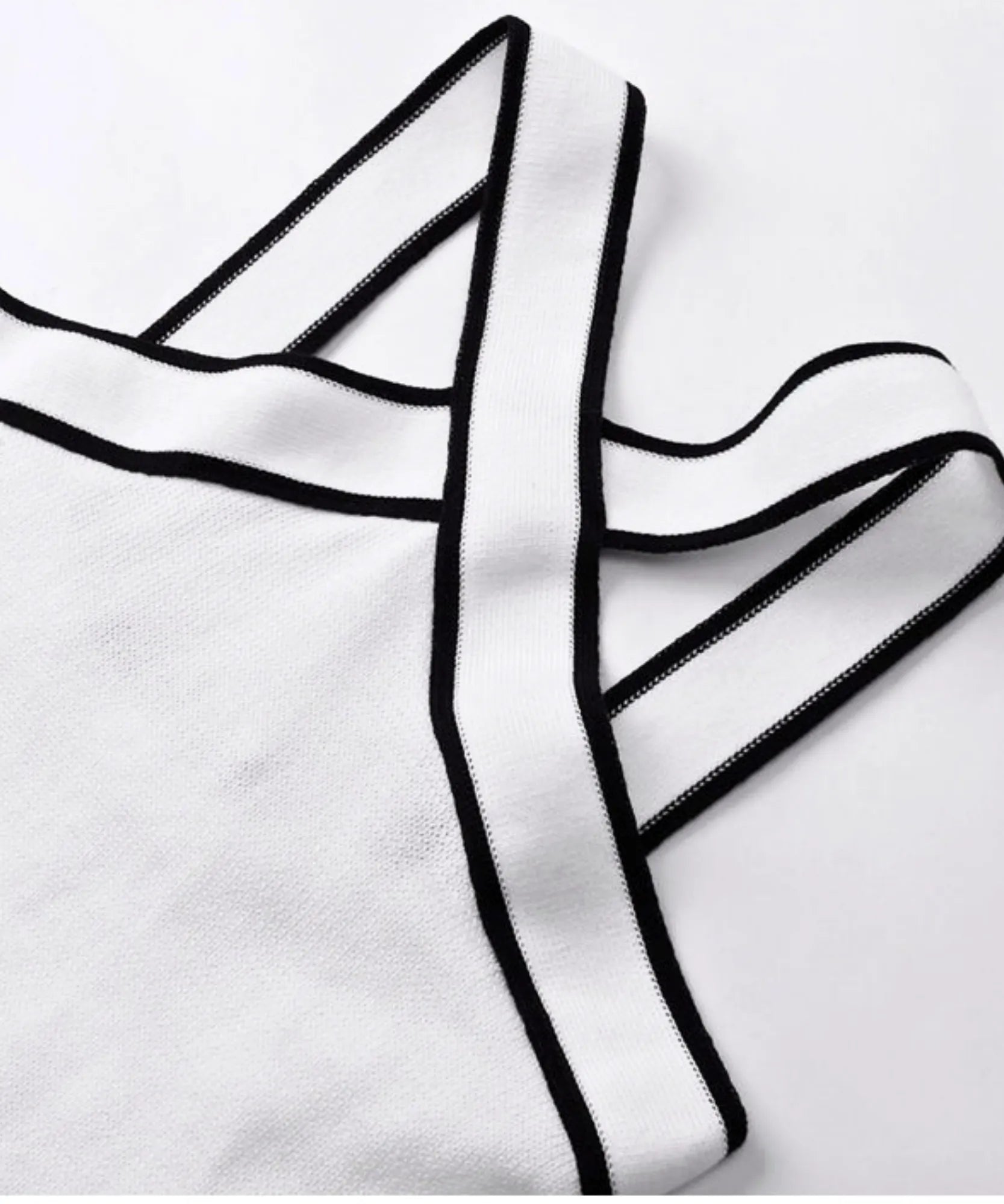Detalhe das alças cruzadas da blusa regata feminina branca com viés preto embutido