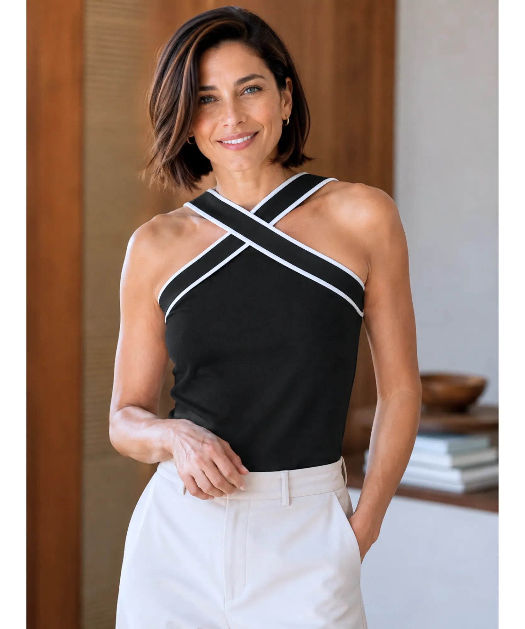 Look com blusa regata feminina preta de alças cruzadas combinada a calça de alfaiataria clara