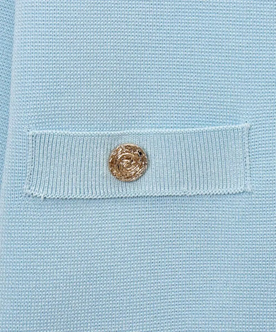 Detalhe do bolsinho com botão dourado da blusa tricot manga curta azul claro