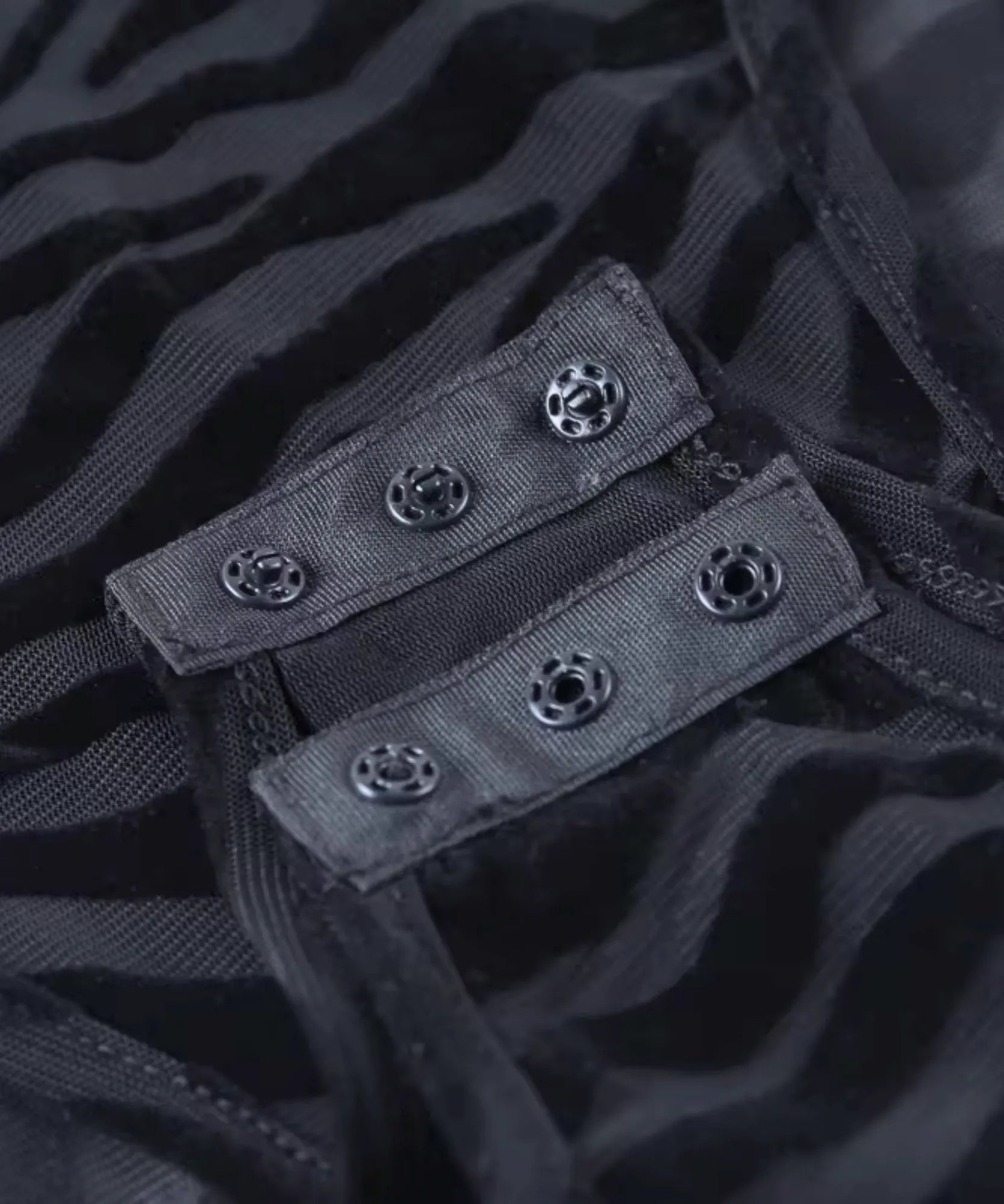 Detalhe dos colchetes de fechamento do body manga longa preto de tule