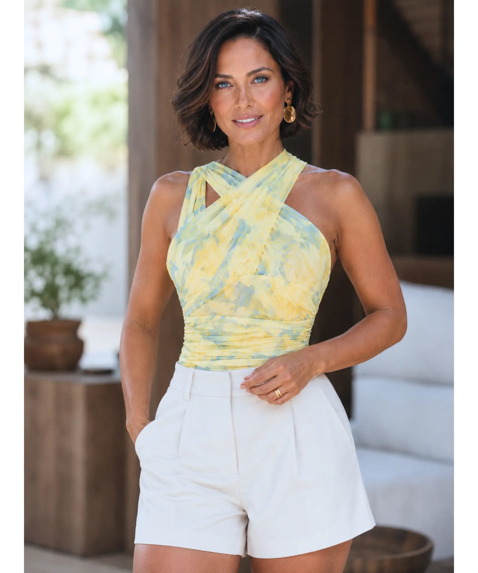 Body de tule amarelo estampado transpassado combinado com shorts de alfaiataria branco