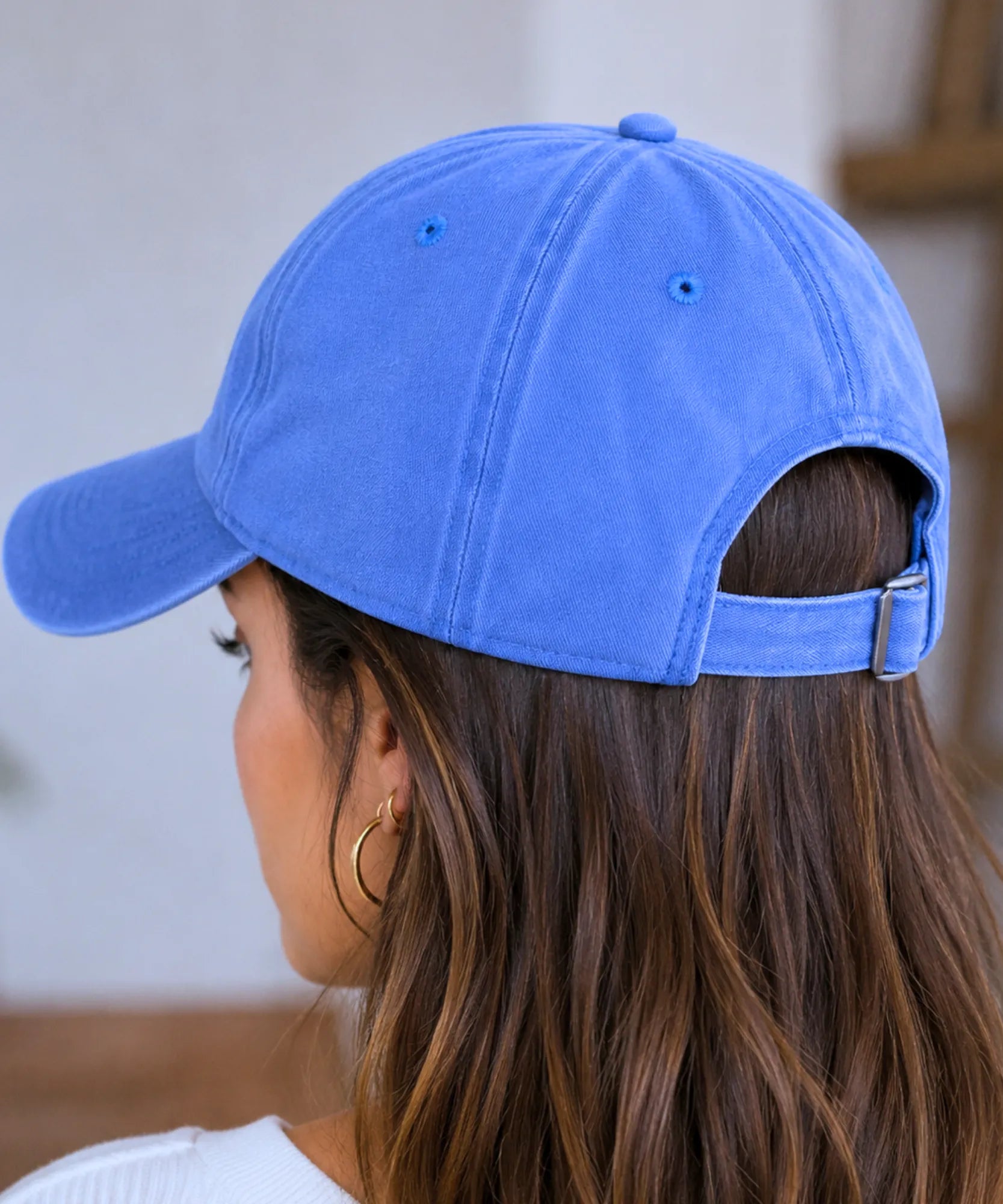 Boné feminino azul visto de costas, mostrando a fivela metálica de ajuste traseira