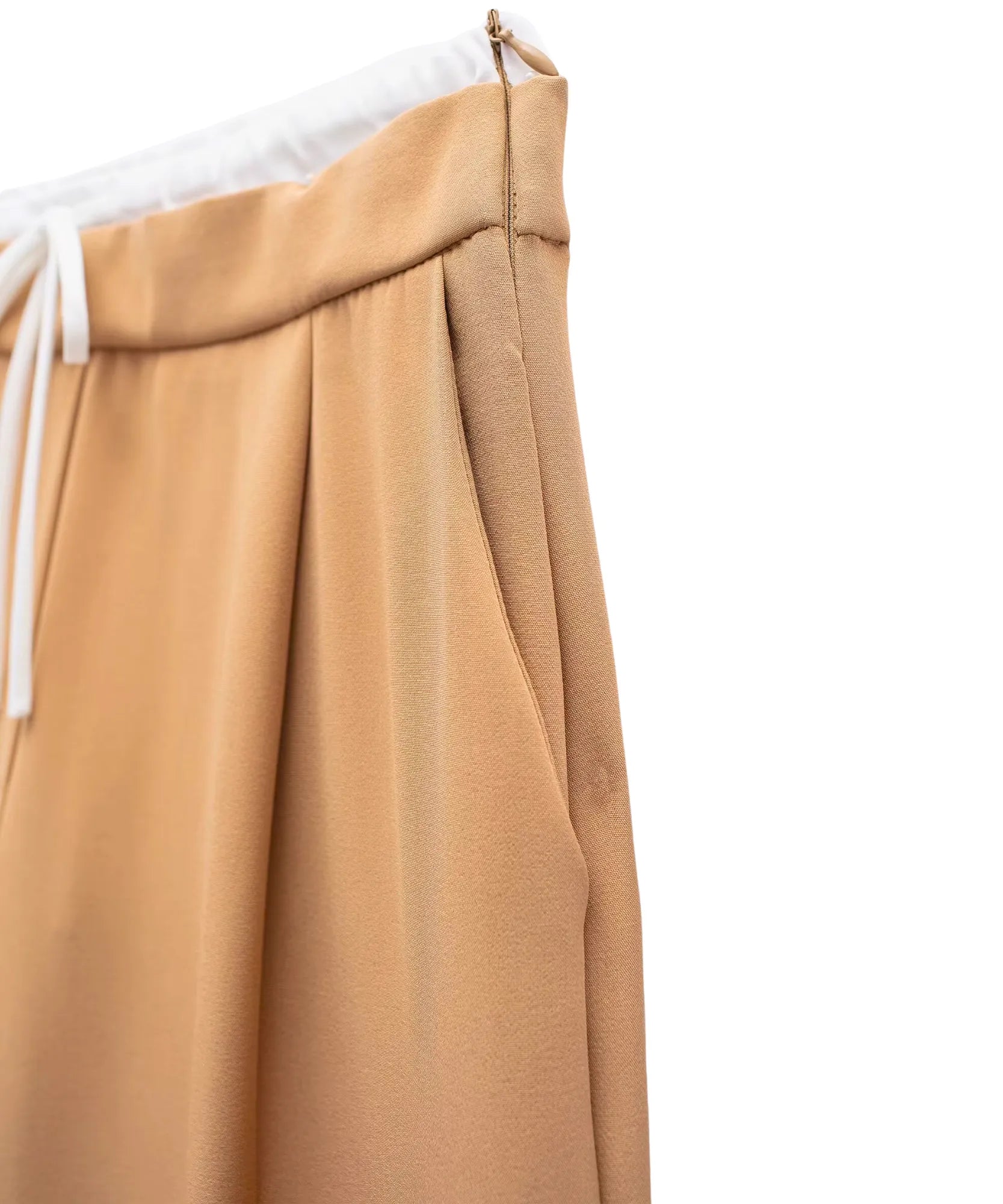 Detalhe macro do bolso lateral embutido na costura da calça alfaiataria wide leg bege camel
