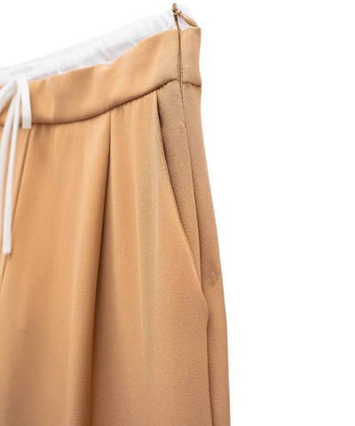 Detalhe macro do bolso lateral embutido na costura da calça alfaiataria wide leg bege camel
