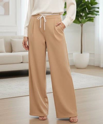 Calça alfaiataria wide leg bege camel mostrando as duas pregas frontais e o cós branco