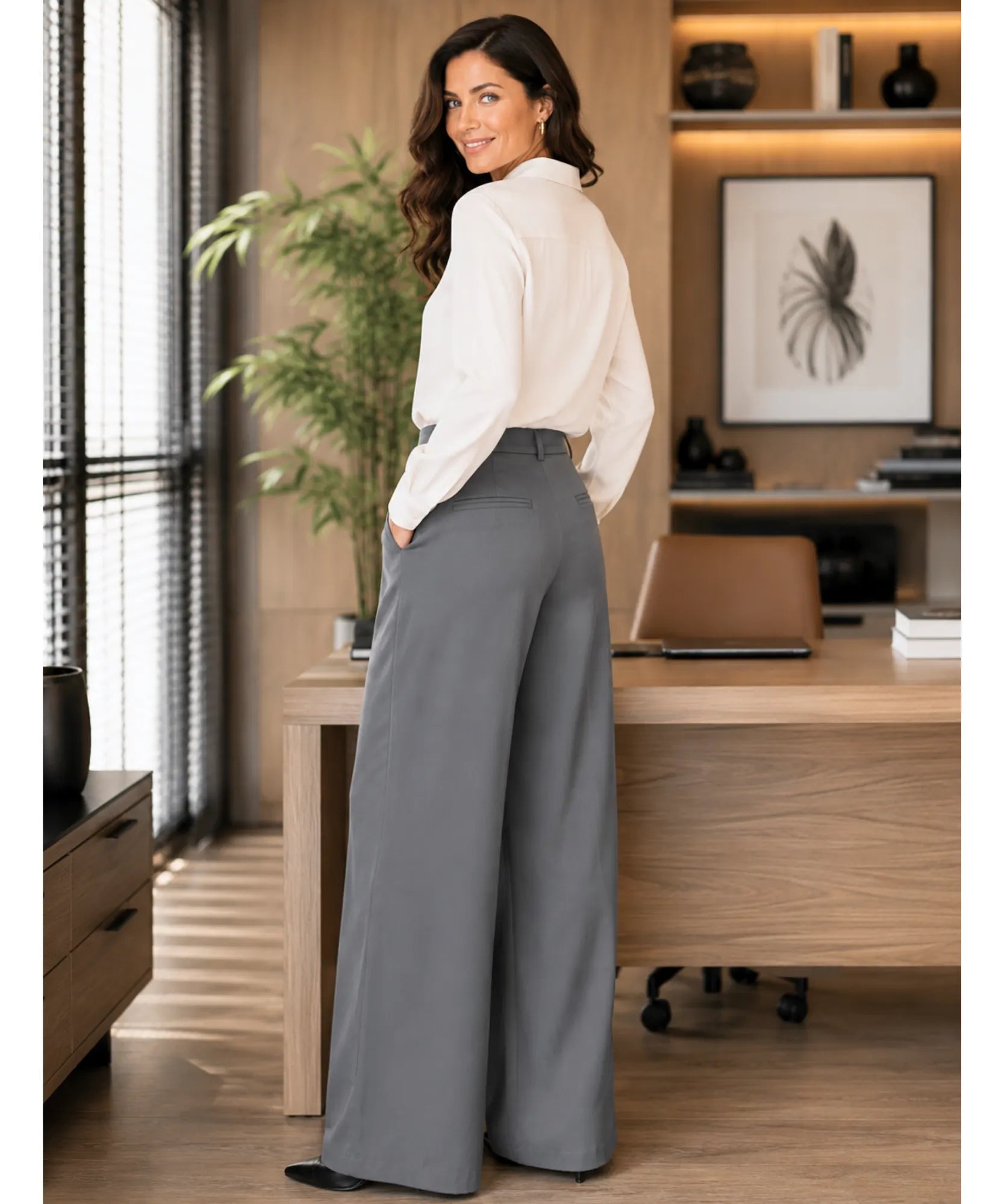 Costas da calça alfaiataria com pregas wide leg cinza, mostrando o caimento reto e a barra ampla