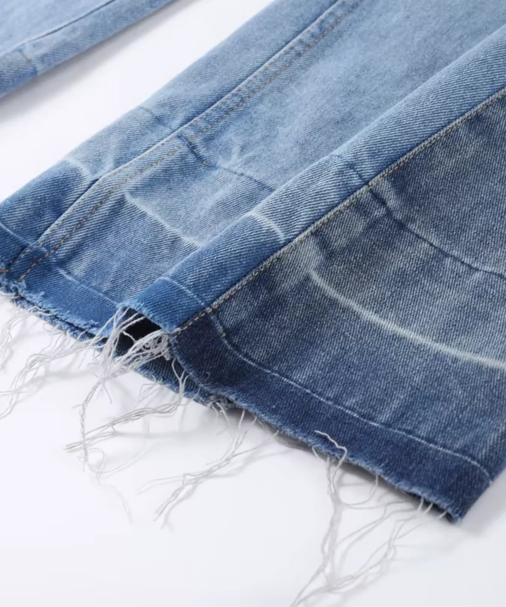 Detalhe da barra com franja crua e costura bicolor da calça jeans wide leg feminina azul