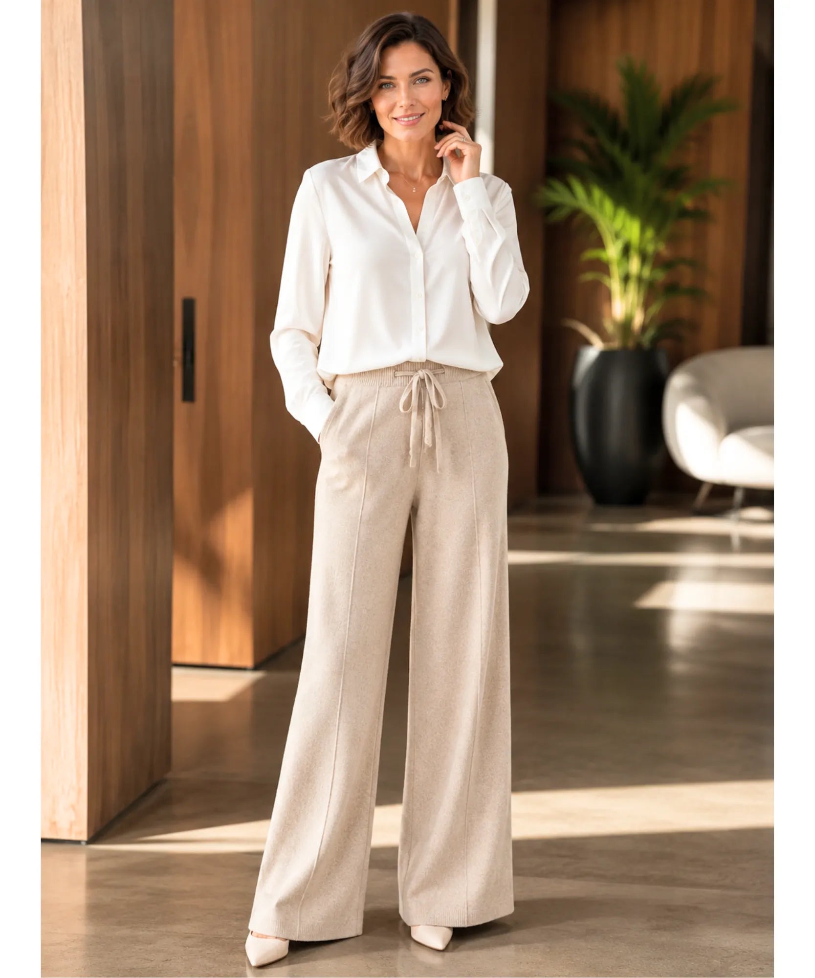 Calça de malha feminina wide leg bege em corpo inteiro, com camisa branca e scarpin nude | Anellimn