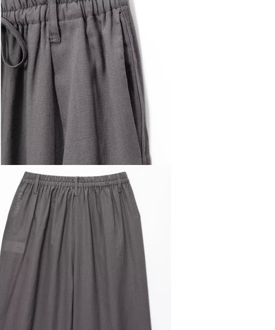 Calça pantalona cinza em still mostrando pregas e passantes do cós