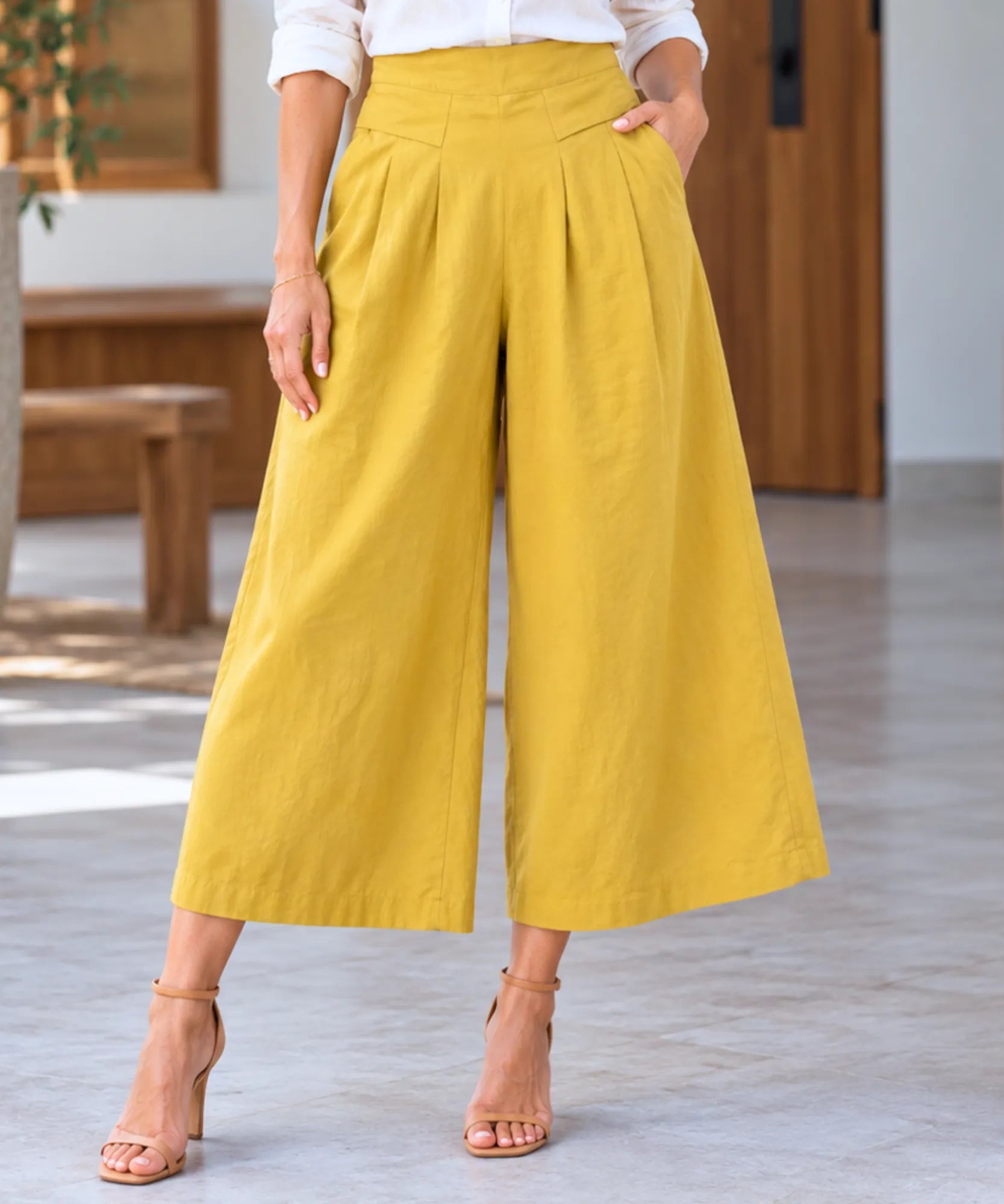 Calça pantalona em linho feminina amarela com cós alto e pregas frontais marcadas