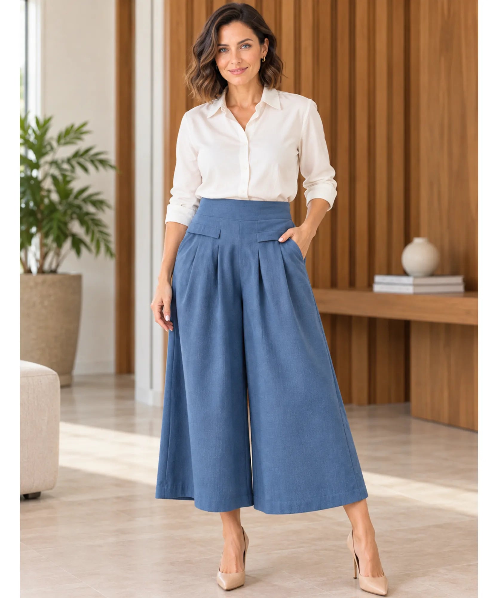 Modelo usando calça pantalona em linho feminina azul de corpo inteiro com camisa off white