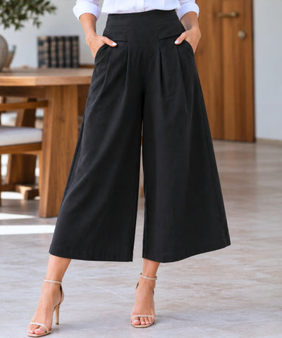 Detalhe das pregas frontais e dos bolsos laterais da calça pantalona em linho feminina preta