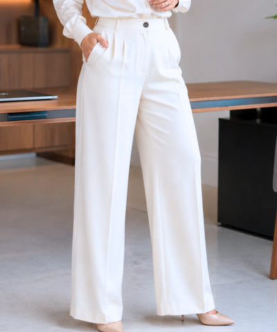 Detalhe do cós alto, das duas pregas frontais, dos passantes e do bolso lateral da calça de alfaiataria off white
