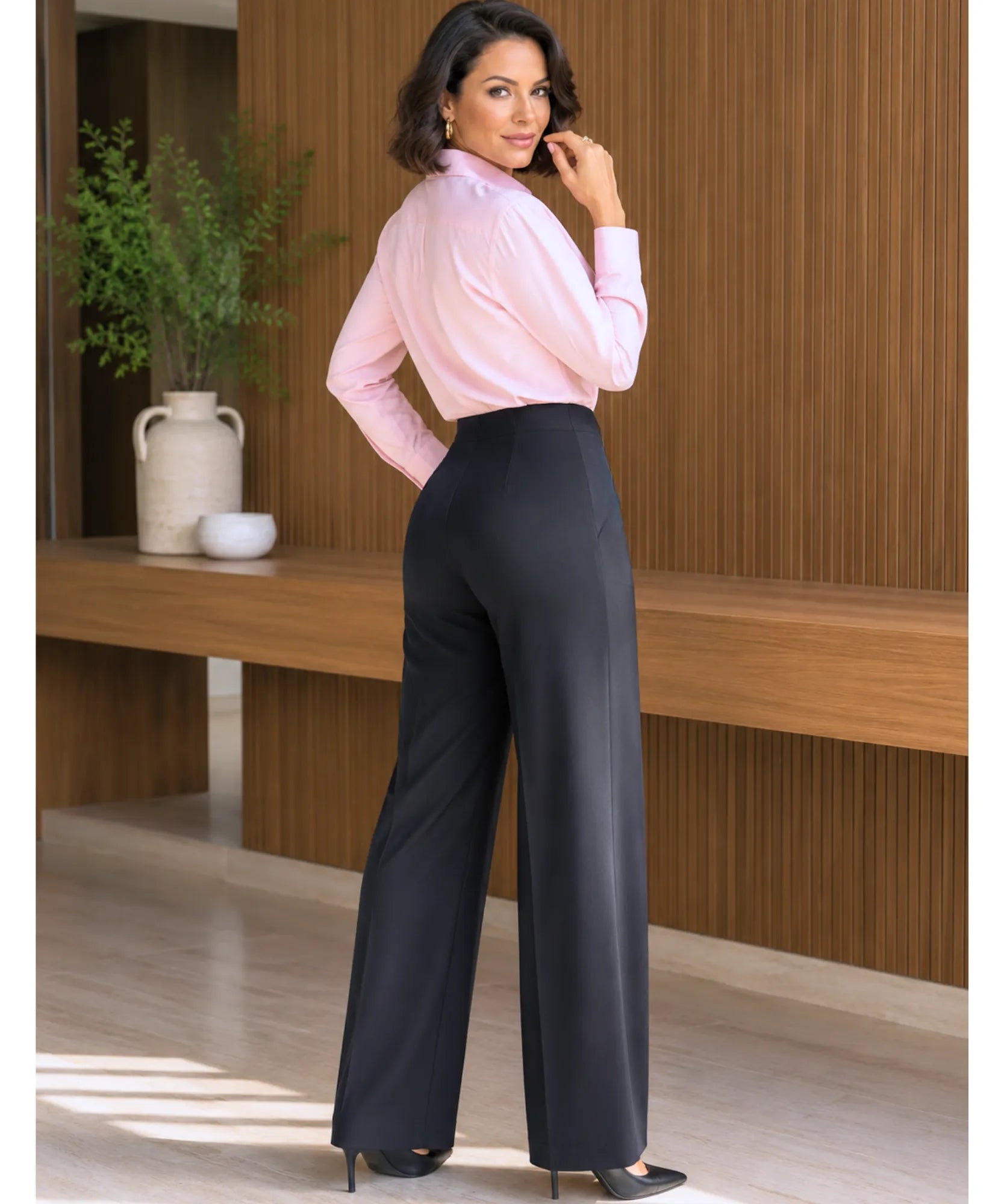 Calça wide leg preta feminina de cintura alta vista de lado, mostrando o caimento largo da perna